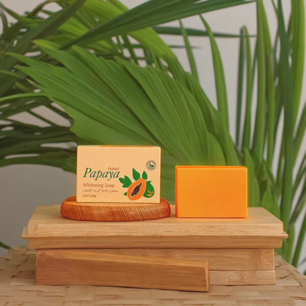 Woman using papaya soap for face cleansing in bathroom mirror